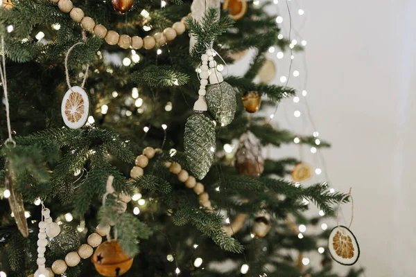 Simple and craft decorations on a Christmas tree in New Year interior. Christmas and New Year concept. Minimalism life concept