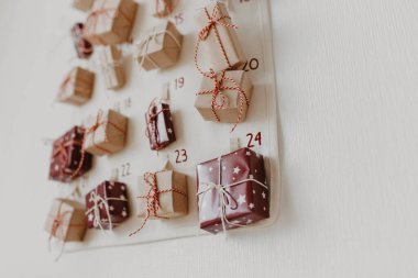 Duvarda Noel takvimi asılı. Çocuklar için paketlenmiş hediyeler. Mevsimlik gelenek. Çevre dostu Noel