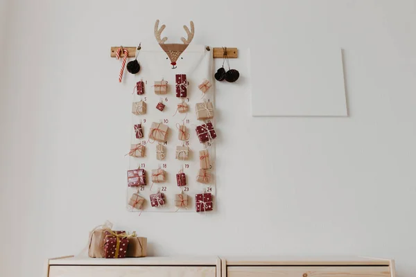 Duvarda Noel takvimi asılı. Çocuklar için paketlenmiş hediyeler. Mevsimlik gelenek. Metin için alanı kopyala