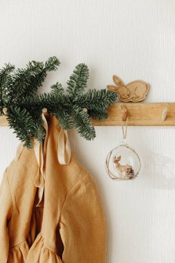 Ahşap askıda asılı keten hardallı kız elbisesi, Noel süslemeleri. - Evet. Çevre dostu Noel.