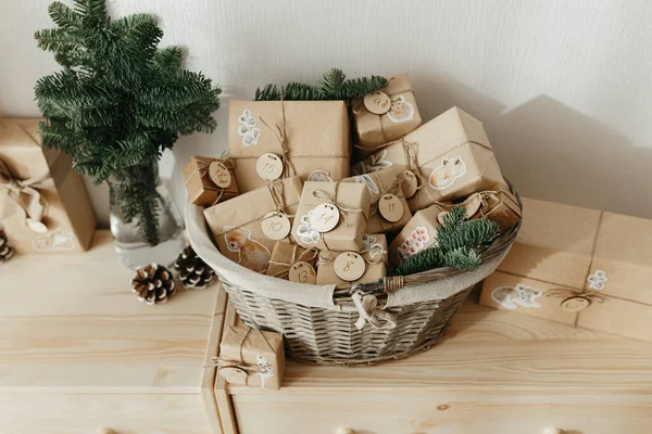 Çocuklar için Noel takvimi. Tahta dolapta duran çocuklar için hediye kutularının olduğu sepet. Çevre dostu Noel.