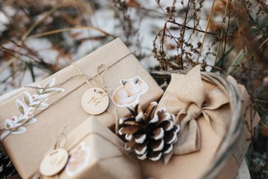 Çocuklar için Noel takvimi. Dışarıda karda duran çocuklar için hediye kutularının olduğu sepet. Çevre dostu Noel.