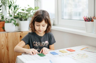 Evde matematik öğrenen beş yaşında tatlı bir kız. Çocuklar için eğitim ve uzak mesafe eğitimi. Evde eğitim kavramı. Coronavirus salgını. Kilitlenme ve okul kapanması.