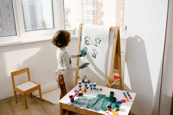 Menina Vestindo Avental Pintura Fazendo Impressões Digitais Papel Cavalete Sala — Fotografia de Stock