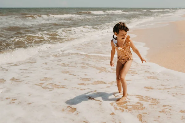 Шість років дівчина в жовтому купальнику на пляжі — стокове фото