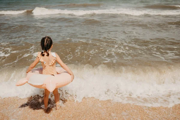 Chica en traje de baño nadando con anillo de natación inflable divirtiéndose en el agua —  Fotos de Stock