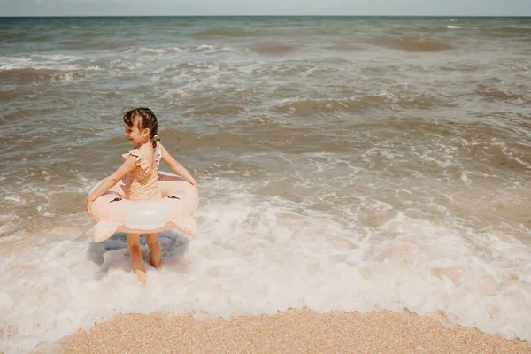 Chica en traje de baño nadando con anillo de natación inflable divirtiéndose en el agua —  Fotos de Stock