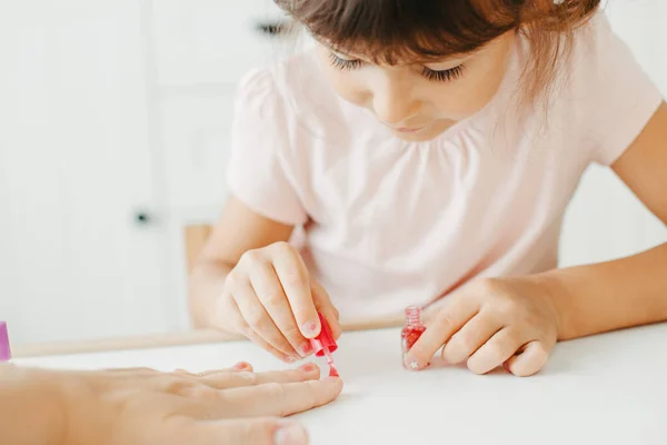Anaokulu öğrencisi, annesinin tırnaklarını boyuyor. — Stok fotoğraf