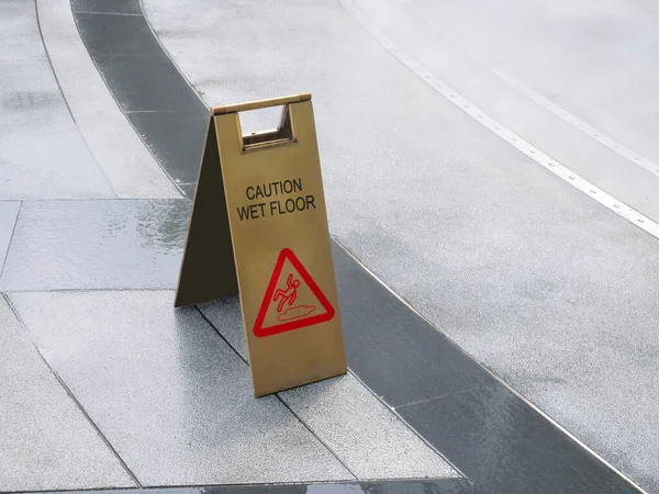 Golden Caution Wet Floor Sign on the Floor