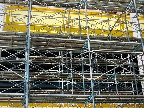 Full Frame Background of Metal Scaffolding Against Yellow Under Construction Building