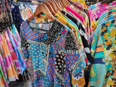 Renkli desenli tişörtler satılık raflarda asılı.