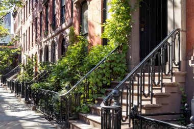 New York, New York 'taki Gramercy Park mahallesinde güneşli bir yaz gününde tarihi kahverengi binalar.