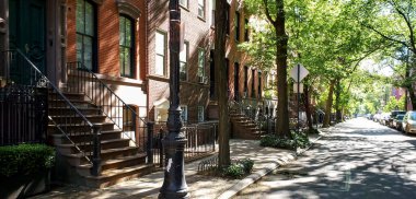 New York 'ta Manhattan' ın East Village semtindeki tarihi kahverengi binaların üzerinde gün ışığı parlıyor.
