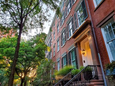 New York 'ta Manhattan' ın West Village mahallesinde sakin bir cadde boyunca eski kahverengi binalar.