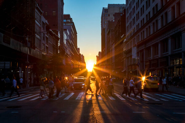 Crowds of diverse people walk across a busy intersection on 5th Avenue in Midtown Manhattan New York City with bright sunlight background