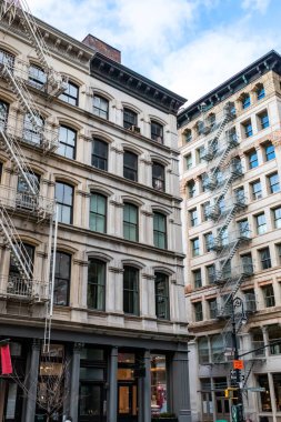 New York 'un SoHo mahallesinde pencereleri ve yangın merdivenleri olan eski apartmanlar.