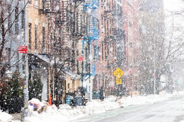 Snowy winter scene with buildings along 12th Street during a snowstorm in the East Village of New York City NYC clipart