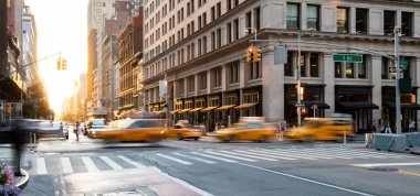 5. Cadde ile 23. Cadde 'nin kesiştiği yerden geçen sarı taksiler New York, ABD' de.
