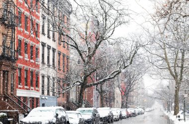 Winter snow storm covering the buildings and cars along 10th Street in the East Village neighborhood of New York City NYC clipart