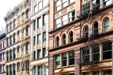 Manhattan 'ın New York şehrinin SoHo mahallesinde pencereleri ve yangın merdivenleri olan eski tarihi binalar bloğu.