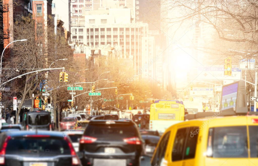 Cars in rush hour traffic along 1st Avenue in Manhattan New York City with sunlight shining between the background buildings