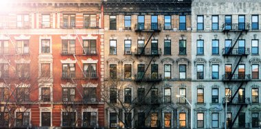 New York 'ta Manhattan' ın Lower East Side mahallesindeki Eldridge Caddesi 'ndeki eski apartmanlarda güneş ışığı parlıyor.