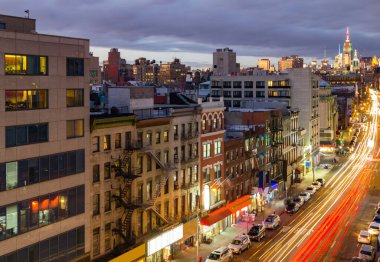 New York Şehri, Bowery 'nin Çin Mahallesi' ndeki binalar boyunca uzanan cadde manzarasıyla meşgul. Gece uzun süre maruz kaldıktan sonra yol boyunca trafik ışıkları yanıyor.