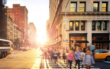 5. Cadde ile 23. Cadde 'nin kesiştiği Manhattan, New York' ta kalabalık bir kalabalık var. Arka plandaki binalar arasında güneş ışığı var.