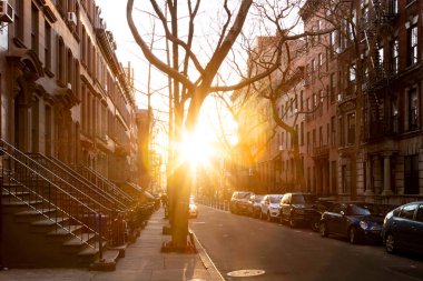 New York 'un West Village semtindeki Perry Caddesi' ndeki tarihi binaların üzerinde gün ışığı parlıyor.