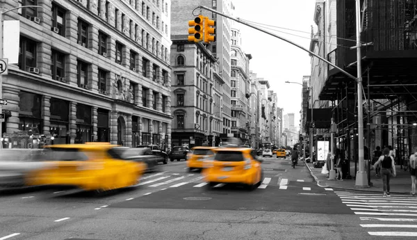 ニューヨーク市の黒と白の景色に隔離された通りを運転する黄色のタクシー — ストック写真