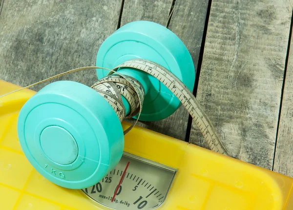 Dumbbells and weight scale machines — Stock Photo, Image