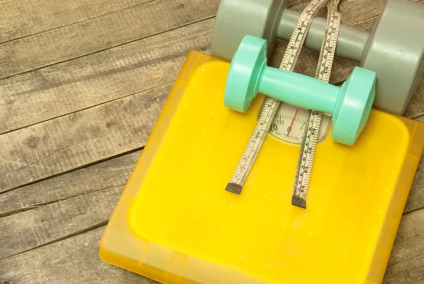 Dumbbells and weight scale machines — Stock Photo, Image