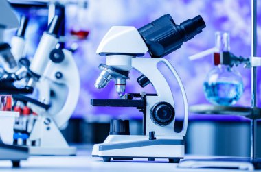 Laboratuvar mavi ışıkları, bilim ve deney konseptinde kimyasal test tüpü ekipmanlarıyla mikroskop ve laboratuvar.