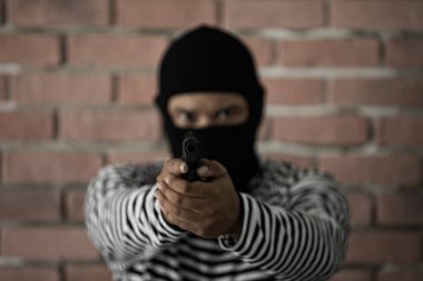Soyguncu silahı doğrultup ateş etmeye hazır.