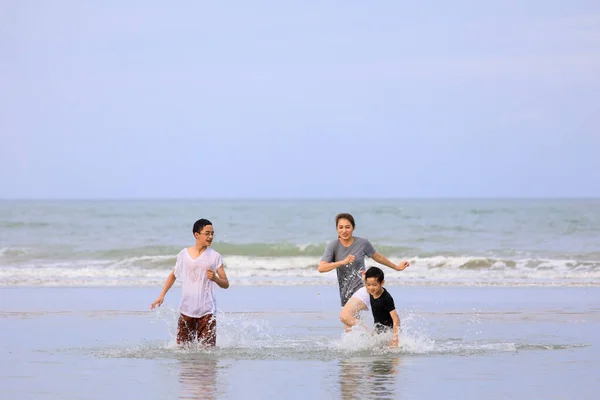 三个亚洲人在热带海滩上玩耍 背景是蓝天 — 图库照片