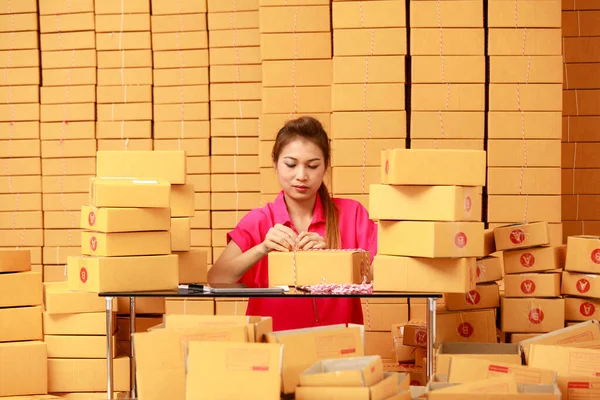 在网上购物生意中 亚洲女人在家里包装盒子 — 图库照片