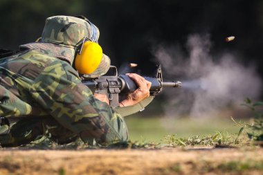 Asker havada mermi kovanlarıyla hedefe ateş ediyor.