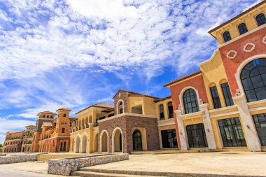 Mavi gökyüzü ve arka planda bulutlar olan klasik tarzda binalar