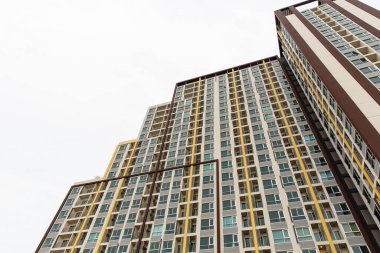 Arkaplanda birçok penceresi ve beyaz gökyüzü olan bina