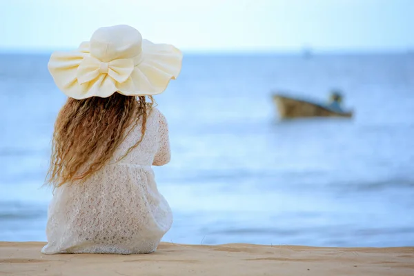 戴大礼帽的女人望着蓝色的大海 — 图库照片