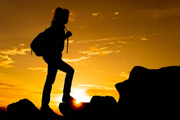 黄昏时分 女人站在山顶上 脚下闪烁着太阳光 — 图库照片