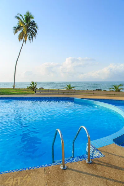 ケープコスト ガーナの青い空の海とヤシの木の横のプール — ストック写真