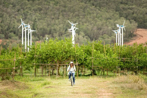 Frau Fährt Fahrrad Auf Feld Mit Windrädern Hintergrund — Stockfoto