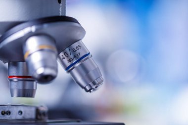 Mikroskop merceğinin ve renkli renkli arkaplan fotokopi küresinin yakın plan görüntüsü. Teknoloji ve araştırma kavramı.