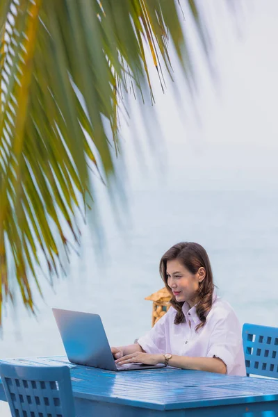 Női Turizmus Kék Íróasztal Mellett Homokos Strand Levelek Kókuszdió Laptop — Stock Fotó