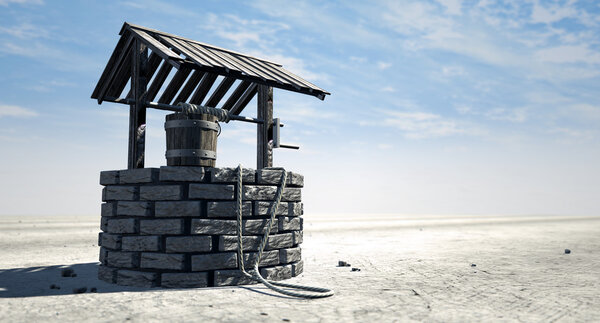 Wishing Well With Wooden Bucket On A Barren Landscape