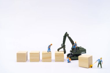Minyatür insanlar İnşaat işçisi Ürünleri beyaz arka planda ahşap blok ile yönetmek Arka planda teslimat kavramı ve metin veya tasarım için kopyalama alanı ile lojistik kavramı.