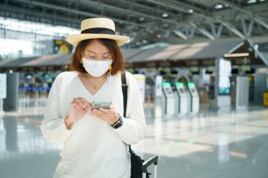 Yüz maskesi takan yeni normal turist havaalanında seyahat ediyor. Covid-19 'dan sonra yeni bir yaşam tarzı yolculuğu. Sosyal uzaklık sağlık sistemi, dikkatli olun ve seyahat balonu konsepti.