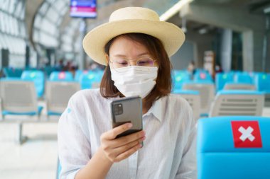 Yüz maskesi takan yeni normal turist havaalanında seyahat ediyor. Covid-19 'dan sonra yeni bir yaşam tarzı yolculuğu. Sosyal uzaklık sağlık sistemi, dikkatli olun ve seyahat balonu konsepti.