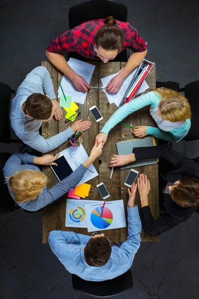 Top view of business people at wooden table